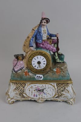 a figurine of a man sitting on top of a clock