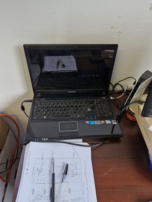 un ordinateur portable posé sur un bureau à côté d'un téléphone portable