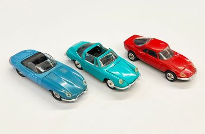 trois petites voitures assises l'une à côté de l'autre sur une surface blanche