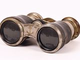 an old pair of binoculars sitting on top of a white surface