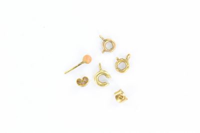 cinq paires de boucles d'oreilles en or posées sur une surface blanche