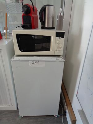 a microwave sitting on top of a refrigerator in a kitchen