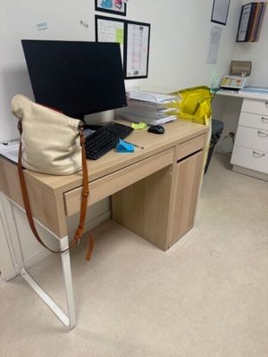 un bureau sur lequel se trouvent un ordinateur portable, un clavier, une souris et un sac