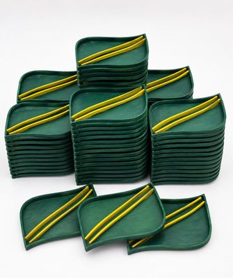 a set of six green trays with yellow stripes on them