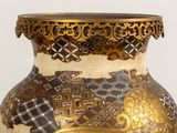 a vase with a gold and black design on it