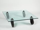 a glass coffee table with wheels on a white background