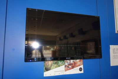 une télévision accrochée au mur dans une pièce bleue