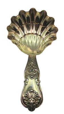 a silver spoon with a shell shaped handle on it