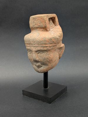 an ancient stone head of a man with a hat on it ' s head