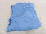 two pairs of blue pants laying on top of a bed
