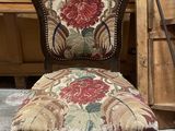 a chair with a floral upholstered back and a wooden frame