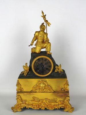 une horloge en or surmontée d'une statue