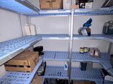 une étagère bleue au milieu d'une pièce remplie d'étagères