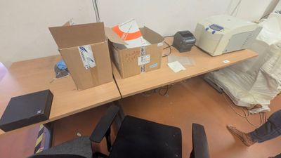 un bureau sur lequel se trouvent un ordinateur, une imprimante et d'autres objets