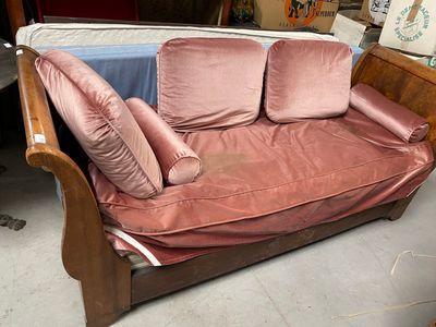 un canapé rose avec des coussins dessus, dans une pièce