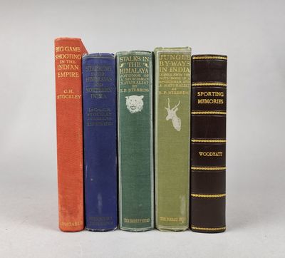 quatre vieux livres sont alignés sur une surface blanche