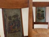 two wooden chairs with pictures on the back of them