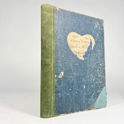 un livre bleu avec une couverture verte sur laquelle est dessiné un cœur