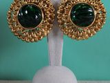 a close up of a pair of green and gold earrings