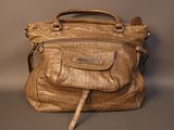 beige leather handbag sitting on top of a gray surface