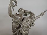 bronze statue of a man and woman with a bird on their shoulders