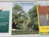 three books on a table with a man fishing