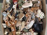 many pairs of shoes in a cardboard box on the ground