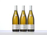 three bottles of white wine sitting on top of a table