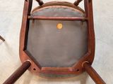 a wooden chair with a brown seat and a brown seat