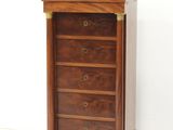 an image of a wooden chest of drawers against a white wall