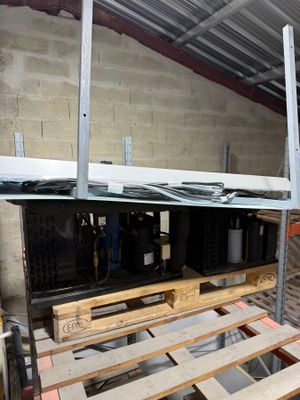 a man that is standing next to some pallets in a building