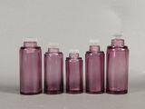 four purple bottles are lined up in a row on a white surface