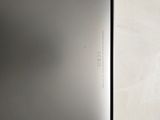 a silver refrigerator that is open on a white surface