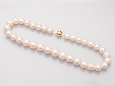 gros plan d'un collier de perles sur une surface blanche