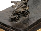 statue of a boy on a skateboard on a wooden base