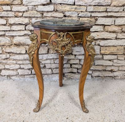 a wooden table with a marble top on a stone floor