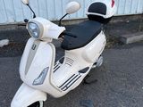 un scooter blanc garé devant un immeuble