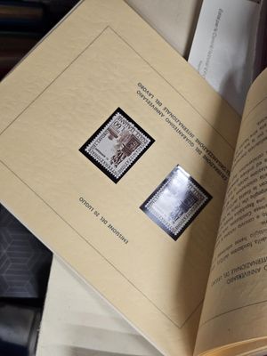 un livre ouvert avec des timbres, posé sur une table