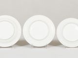 three white plates sitting on top of each other on a white surface