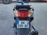 a motorcycle that is parked on the street with a tow truck in the background