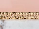 an image of a gold plated bracelet on a marble surface
