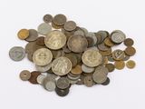 a pile of old coins on a white surface