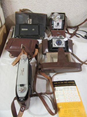 many different types of old cameras on a table