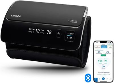 an image of a black alarm clock sitting next to a cell phone