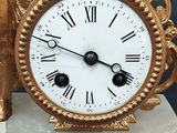 a gold clock sitting on top of a marble base