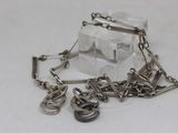 a silver chain with charms attached to it on a white surface