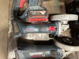 two corded drillers and two other tools on a table