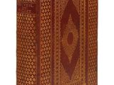 un vieux livre à la couverture brune posé sur une surface blanche