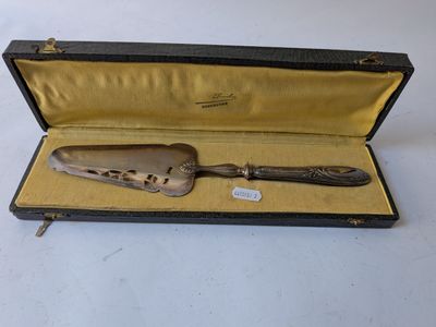 an antique silverware spoon and knife in a case on a white surface