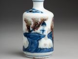 a small blue and white vase with a painting on it